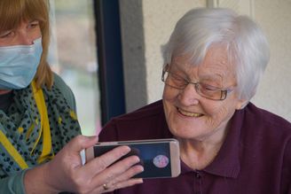 Mujer mayor con cuidadora Cuyve haciendo videollamada
